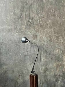 midgard gelenklampe als stehleuchte auf skulpturellen Holzstativ
