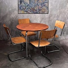 Slezák ST 51 | Bauhaus Stahlrohr Tisch - Vintage Designklassiker Der Slezák ST 51 ist ein herausragendes Beispiel für die europäische Stahlrohr-Moderne der 1930er bis 1950er Jahre. Dieser runde Esstisch der tschechischen Manufaktur Robert Slezák besticht durch seine architektonische Linienführung und die kompromisslose Verarbeitungsqualität. Er ist die perfekte Wahl für Liebhaber des authentischen Bauhaus-Designs und industrieller Ästhetik. Architektonisches Design mit X-Gestell Das markanteste Merkmal beim Slezák ST 51 ist das X-förmig gekreuzte Untergestell aus verchromtem Präzisionsstahlrohr. Diese geometrische Konstruktion verleiht dem Tisch eine außergewöhnliche Stabilität und eine schwebende Optik. Die Kombination aus kühlem Chrom und der warmen, furnierten Tischplatte aus Buchensperrholz (Plywood) erzeugt einen spannungsvollen Kontrast, der jedes moderne Interieur aufwertet. Qualität und Zustand Jeder Slezák ST 51 Tisch wurde für maximale Langlebigkeit gefertigt. Dieses Vintage-Exemplar befindet sich in einem sehr guten Zustand. Die Verchromung weist einen hervorragenden Glanz auf, während die Holzplatte eine ehrliche, über Jahrzehnte gewachsene Patina besitzt. Dies unterstreicht die Authentizität dieses Designklassikers und macht ihn zu einem wertbeständigen Sammlerstück.